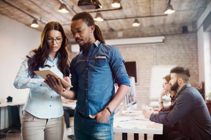 Two young professionals looking at a tablet