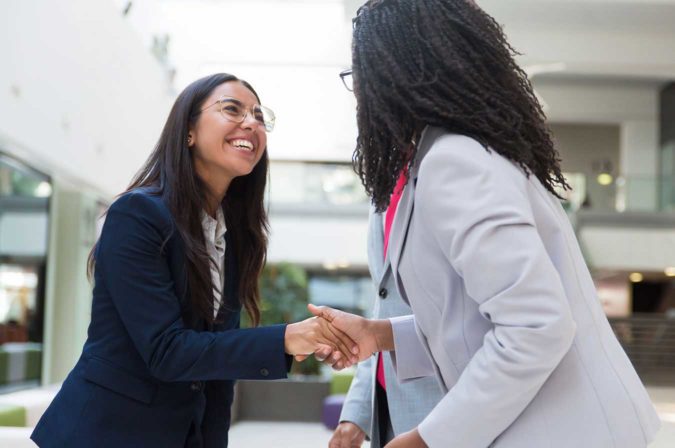 a young professional shaking the hand of another person
