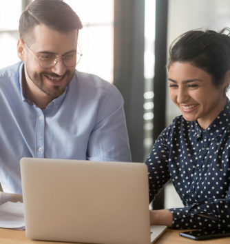 two colleagues having a discussion over a laptop in the workplace