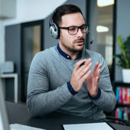 a man wearing a headset and gesturing while speaking