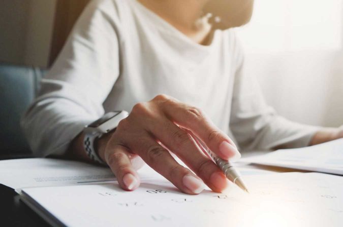 A hand holding a pen over paper